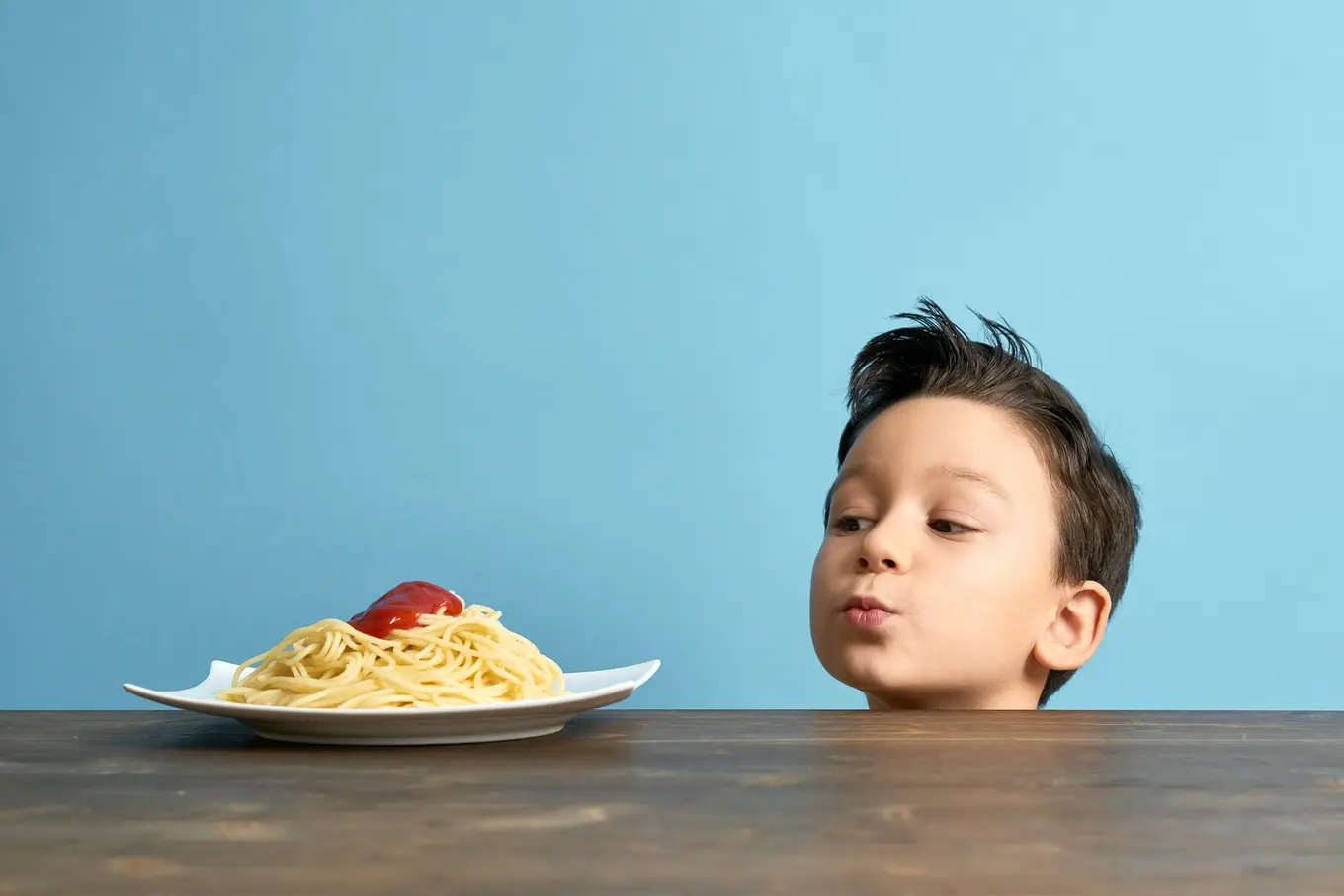 dziecko patrzące na spaghetti